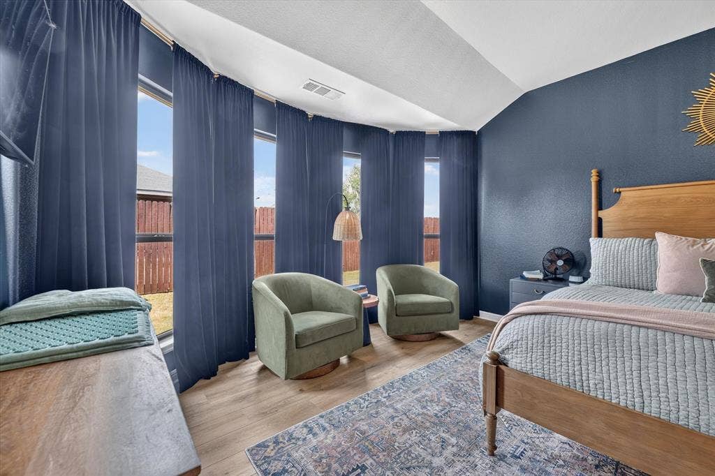 424 Foxcraft Drive, Fort Worth, TX 76131 Vaulted ceiling, wood-finish flooring, multiple windows with full-length drapery, and a wood bed frame