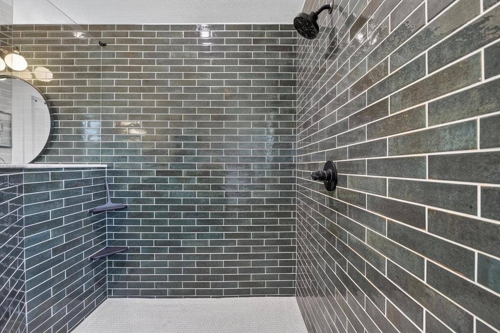 424 Foxcraft Drive, Fort Worth, TX 76131 Walk-in shower with dark subway tile, integrated corner shelves, mosaic tile flooring, and matte black fixtures