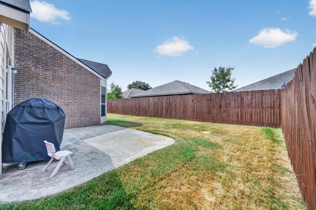 424 Foxcraft Drive, Fort Worth, TX 76131 Expansive backyard featuring a privacy fence, concrete patio, and brick exterior