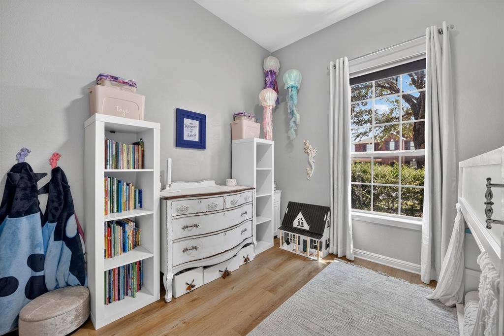 424 Foxcraft Drive, Fort Worth, TX 76131 Vaulted ceiling, wood-finish flooring, white trim, large window with grid pattern, and neutral wall color