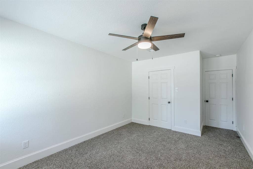 4133 Sherry Lane, Beverly Hills, TX 76711 Textured walls, ceiling fan with integrated lighting, two paneled doors, and carpet flooring