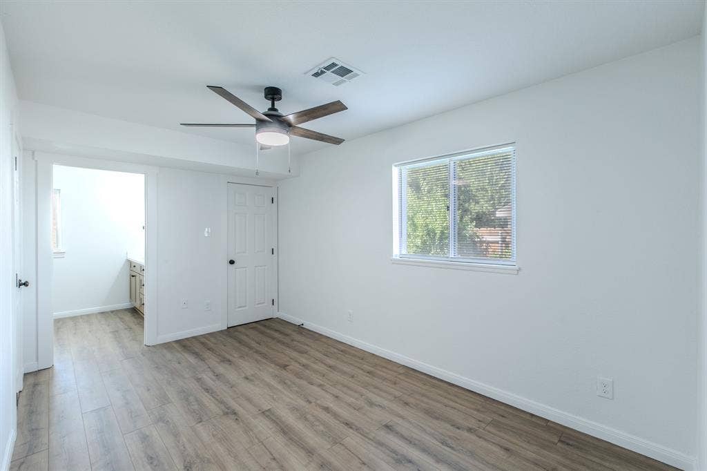 4133 Sherry Lane, Beverly Hills, TX 76711 Wood-finish flooring, white walls, ceiling fan with light fixture, single window with blinds, and white interior doors
