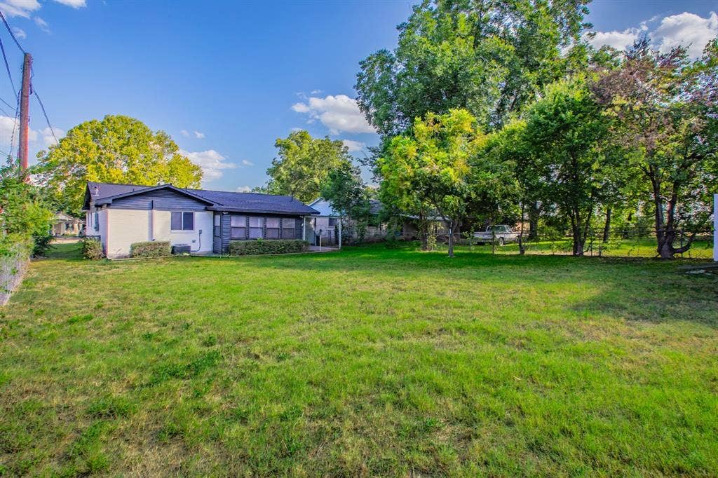4133 Sherry Lane, Beverly Hills, TX 76711 Expansive rear yard featuring a manicured lawn and mature trees