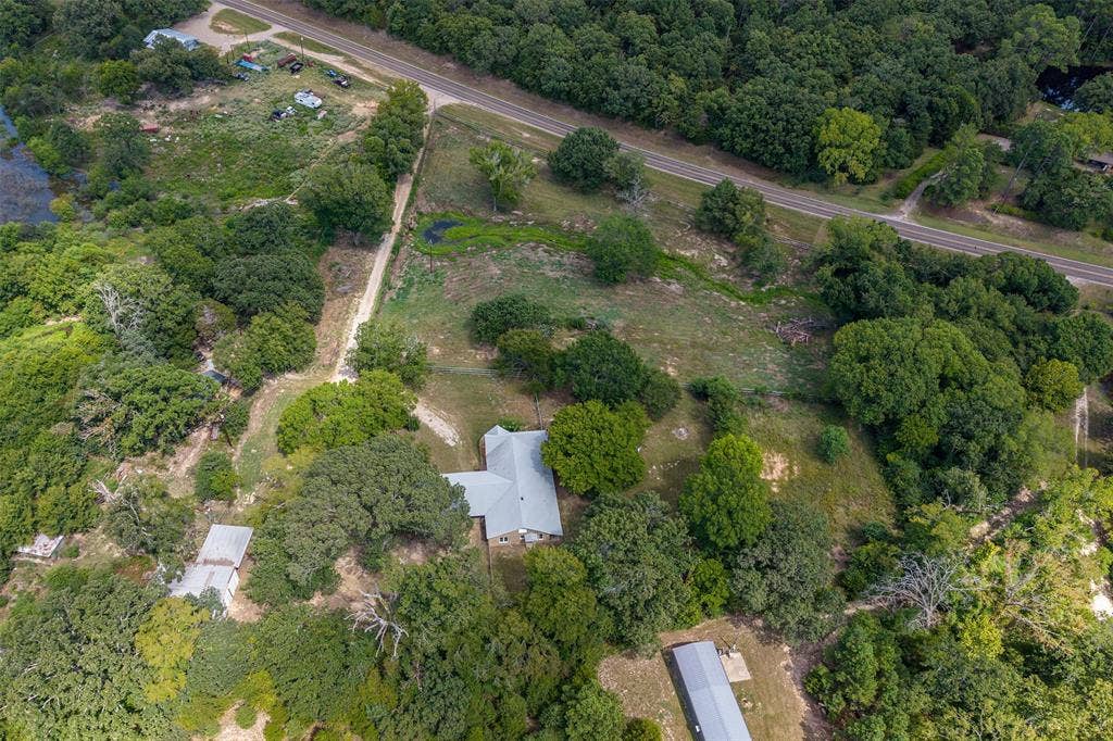 5250 Fm 2494, Athens, TX 75751 Expansive natural landscape with mature trees, a visible road, and a pond feature