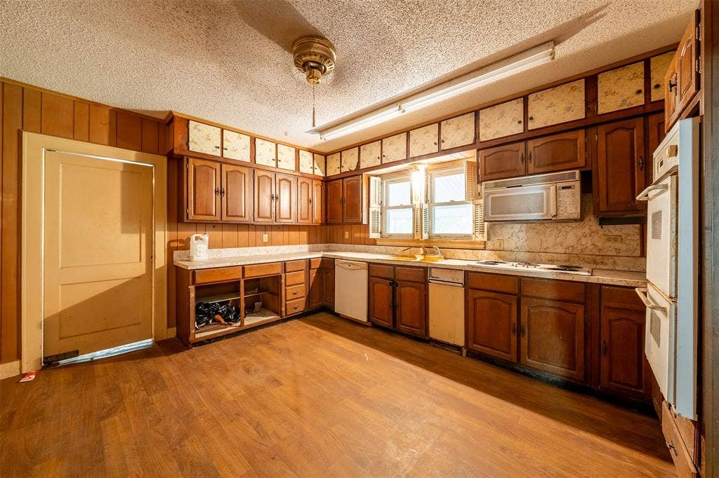5250 Fm 2494, Athens, TX 75751 Kitchen with wood-finish flooring, wood paneling, extensive wood cabinetry, white countertops, and a double wall oven