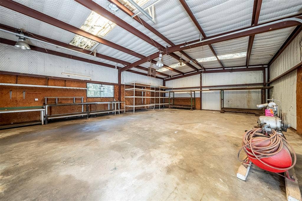 5250 Fm 2494, Athens, TX 75751 Spacious interior featuring a concrete floor, exposed structural beams, ceiling-mounted lighting, and integrated shelving units