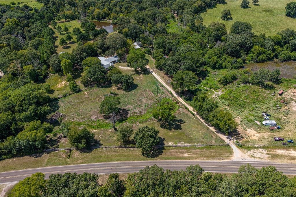 5250 Fm 2494, Athens, TX 75751 Rural property featuring extensive tree coverage, a private pond, and a gravel drive