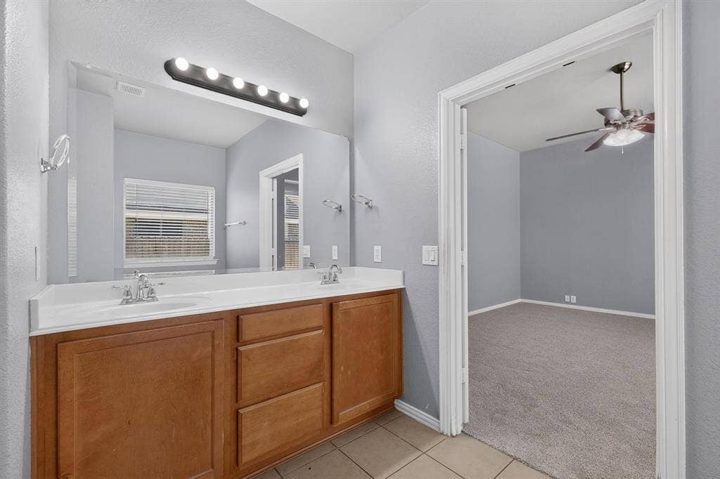 Dual vanity with wood-finish cabinetry and chrome fixtures