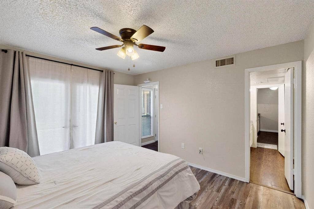 Ceiling fan with integrated lighting, wood-finish flooring, and white interior doors