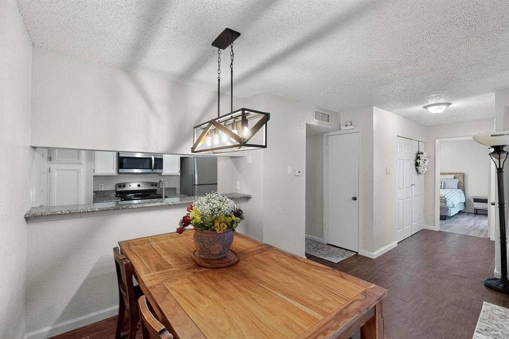 Dining area featuring a linear chandelier and wood-finish flooring