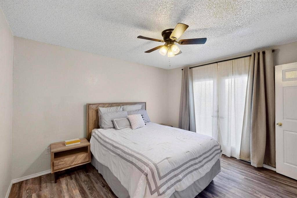 Wood-finish flooring, ceiling fan with integrated lighting, and a white door with frosted glass insert