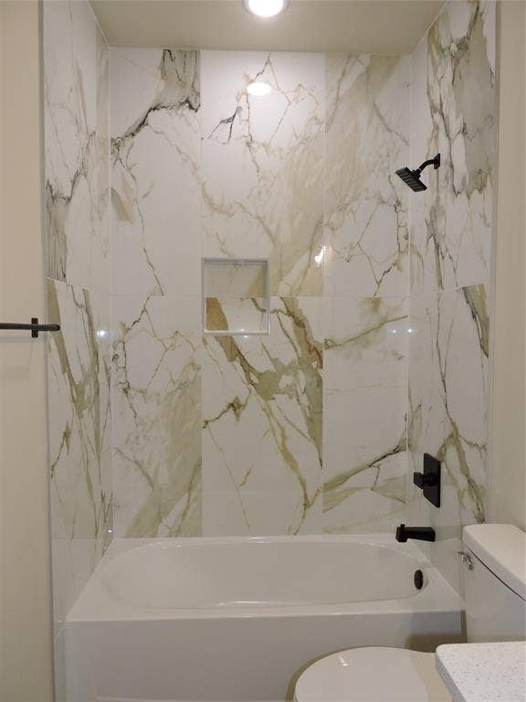 106 Navajo Drive, Mabank, TX 75156 Bathtub with full-height tile surround, integrated shower niche, matte black fixtures, and a ceiling-mounted light fixture