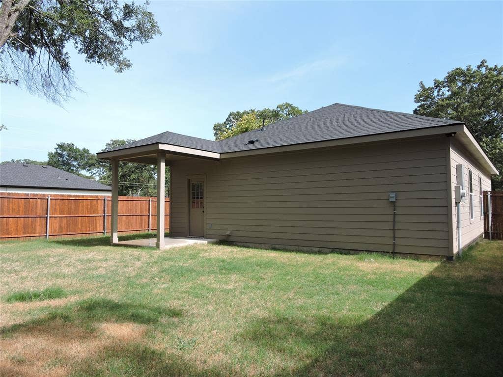 106 Navajo Drive, Mabank, TX 75156 Private backyard with wood fencing, featuring a covered patio, neutral-toned siding, and a dark shingle roof