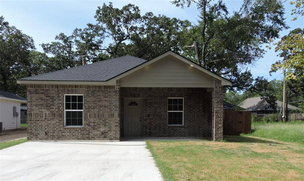 106 Navajo Drive, Mabank, TX 75156 Brick exterior with a covered porch entry, asphalt shingle roof, and a concrete driveway