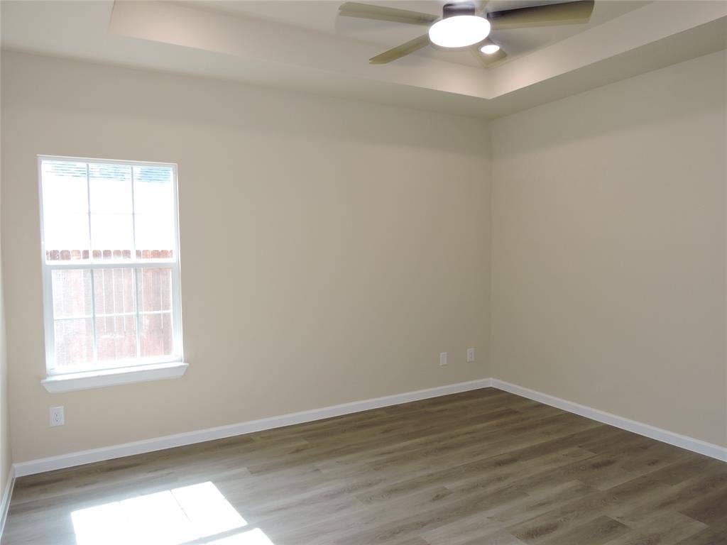 106 Navajo Drive, Mabank, TX 75156 Wood-finish flooring, single window, tray ceiling, and a ceiling fan with integrated lighting