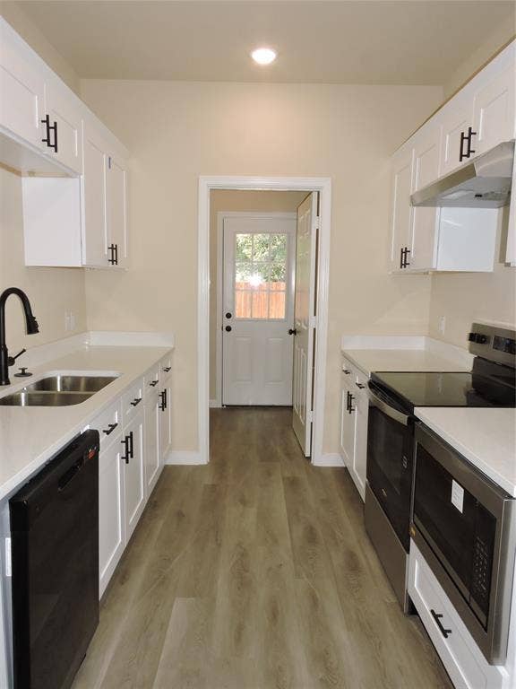 106 Navajo Drive, Mabank, TX 75156 Galley kitchen featuring white cabinetry, light countertops, wood-finish flooring, stainless steel appliances, and matte black hardware