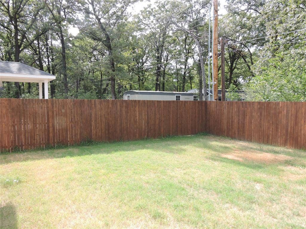 106 Navajo Drive, Mabank, TX 75156 Fenced property featuring a grass lawn and a covered patio structure