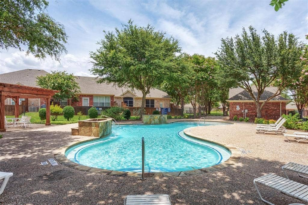 2829 Mott Street, Plano, TX 75025 Resort-style resort pool featuring a curved design with sun loungers and mature landscaping