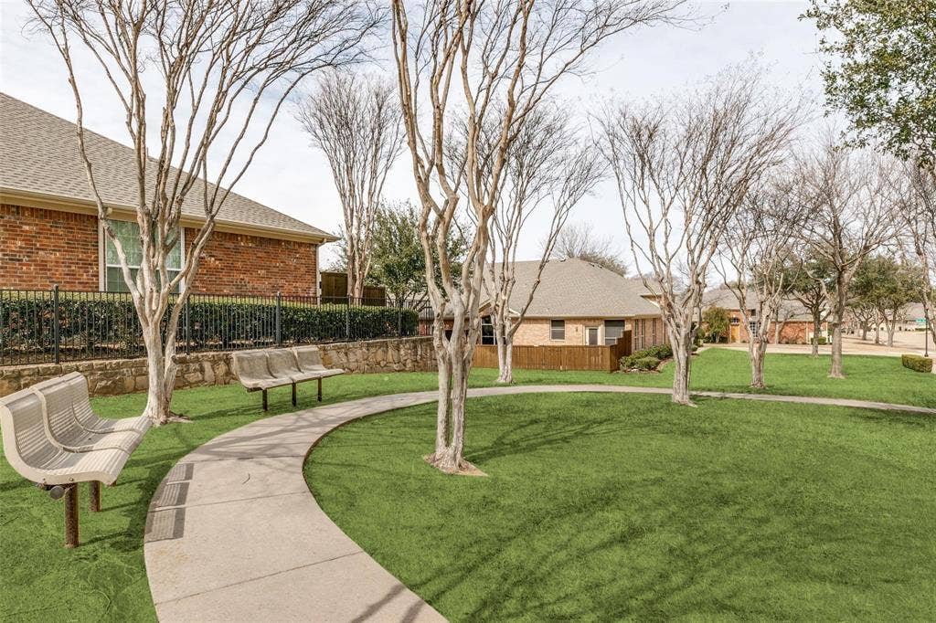 2829 Mott Street, Plano, TX 75025 Manicured green space with mature trees, curved concrete pathway, and multiple benches