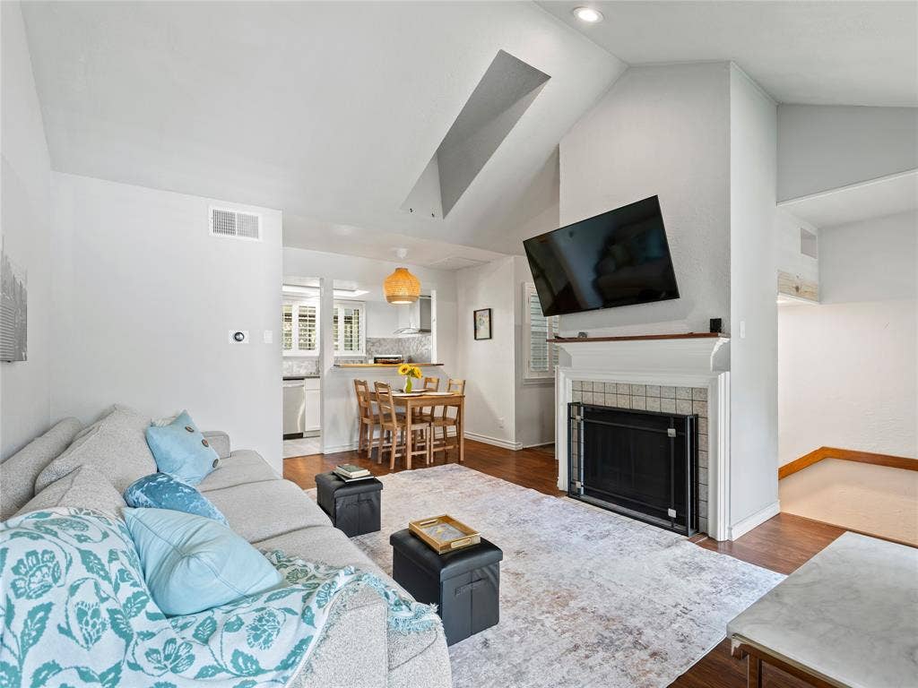 6220 Bentwood Trail, #205, Dallas, TX 75252 Vaulted ceiling, recessed lighting, wood-finish flooring, fireplace with tile surround, kitchen with white appliances