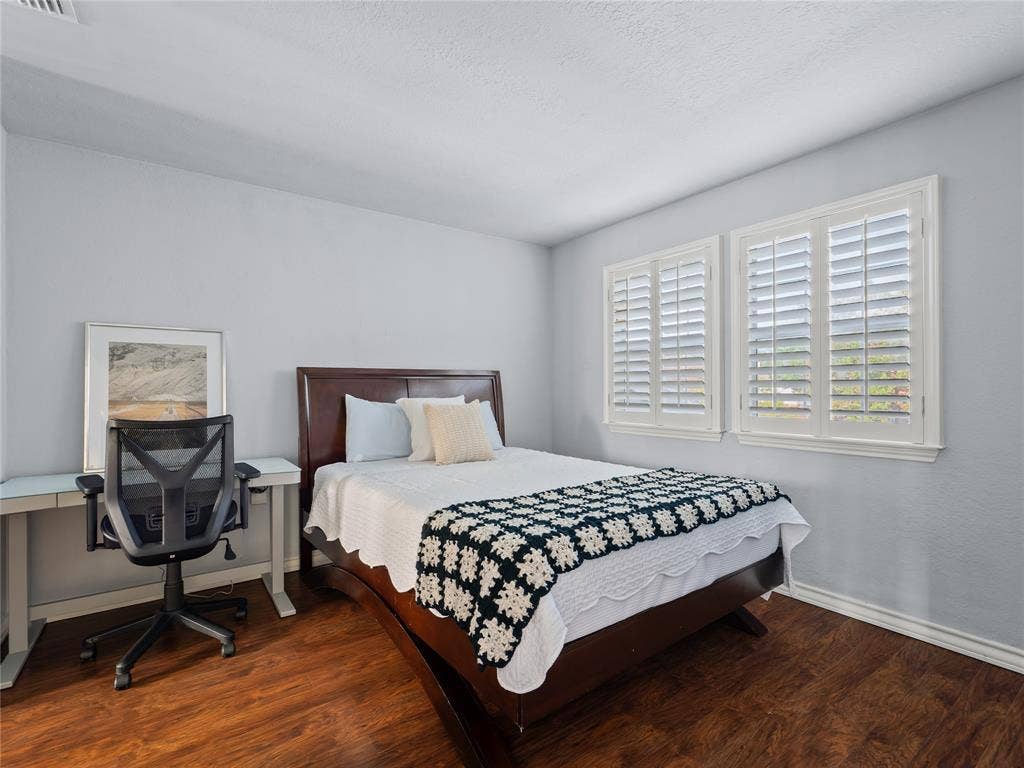 6220 Bentwood Trail, #205, Dallas, TX 75252 Wood-finish flooring, white walls, and dual windows with plantation shutters
