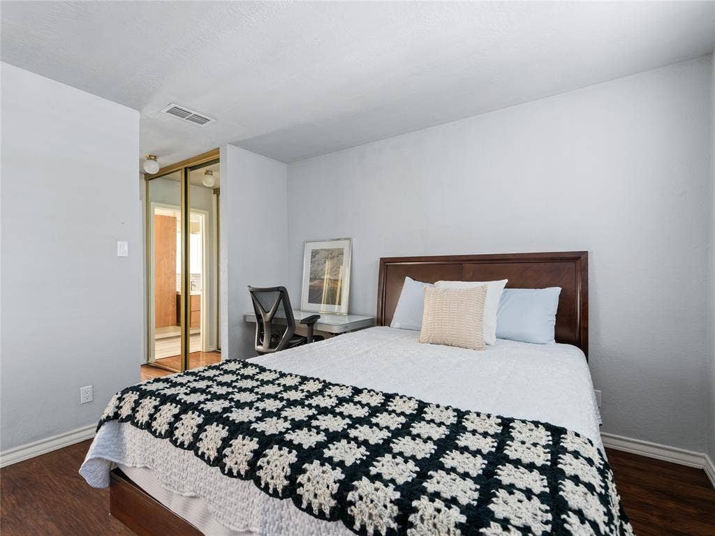 6220 Bentwood Trail, #205, Dallas, TX 75252 Wood-finish flooring with light-colored walls and a gold-framed mirrored closet