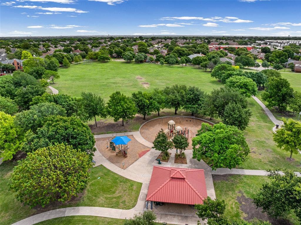 2705 Ithaca Court, Plano, TX 75025 Expansive green space featuring mature trees, a dedicated playground area, paved walking paths, and a covered pavilion