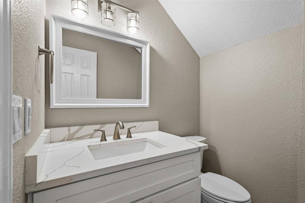 2705 Ithaca Court, Plano, TX 75025 Vanity with an integrated rectangular sink, bronze-finish faucet, and white countertop with veining