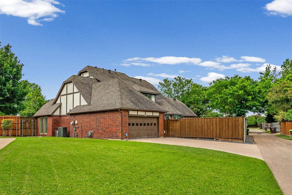 2705 Ithaca Court, Plano, TX 75025 Brick exterior with a peaked roofline, attached garage, and a lush green lawn