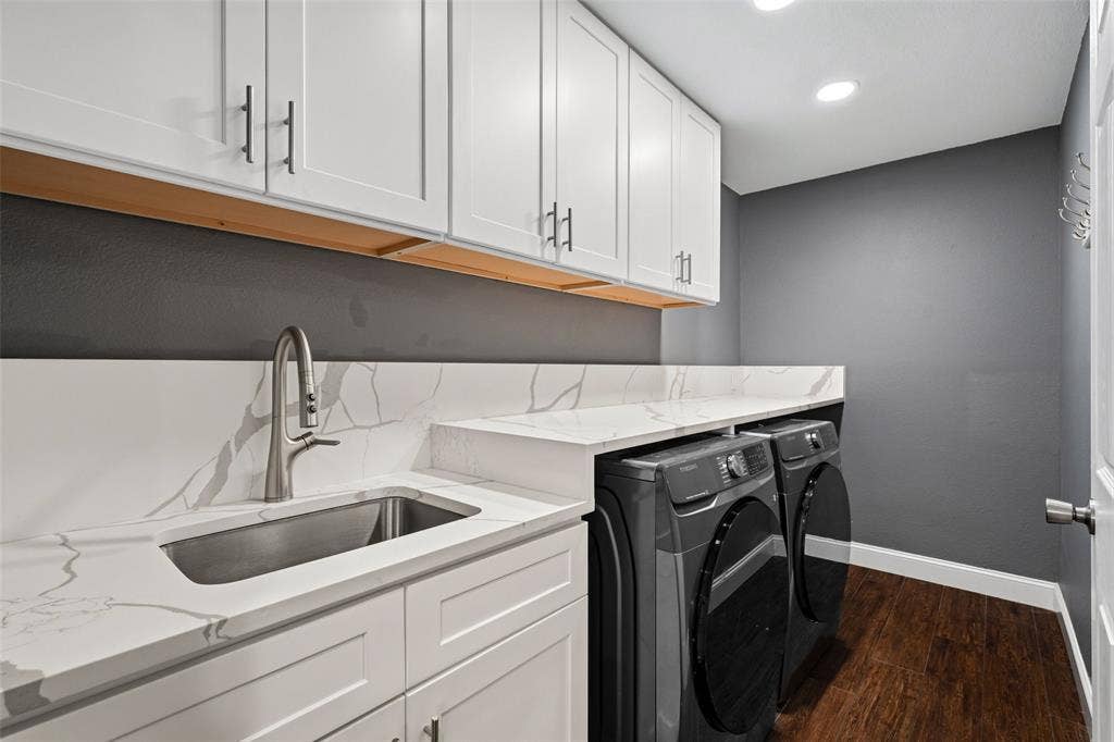 2705 Ithaca Court, Plano, TX 75025 White shaker cabinetry with dark pulls, a stainless steel sink, and light countertops with veining