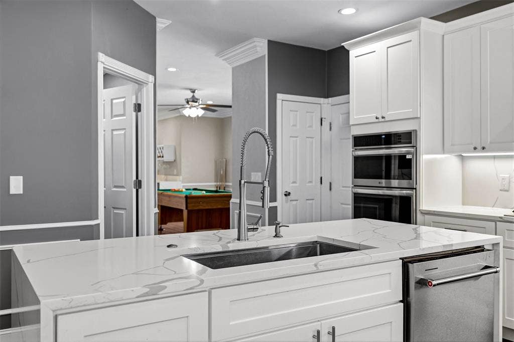 2705 Ithaca Court, Plano, TX 75025 Kitchen island with an undermount sink, gooseneck faucet, and integrated dishwasher