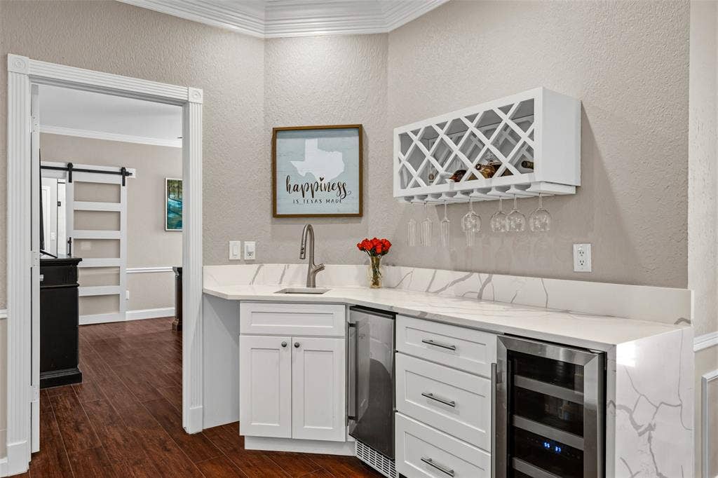 2705 Ithaca Court, Plano, TX 75025 Built-in wet bar featuring a beverage cooler, wine refrigerator, and quartz countertops with a waterfall edge