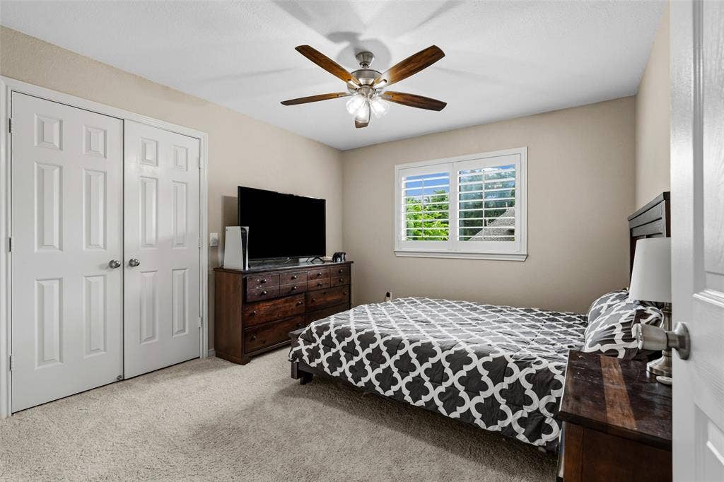 2705 Ithaca Court, Plano, TX 75025 Plush carpet flooring, wood-finish ceiling fan, window with plantation shutters, and paneled closet doors