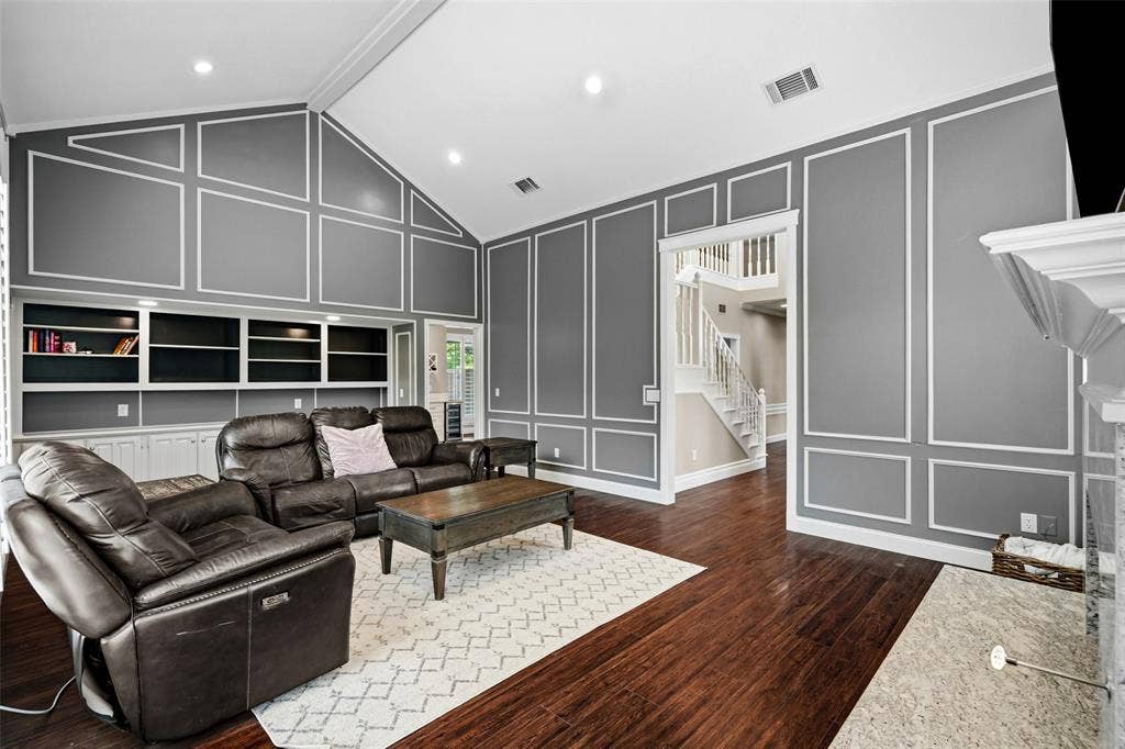 2705 Ithaca Court, Plano, TX 75025 Vaulted ceiling, built-in shelving, wood-finish flooring, decorative wall molding, and a fireplace surround