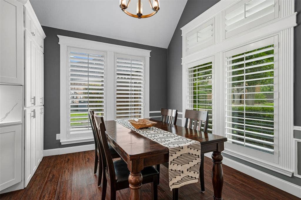 2705 Ithaca Court, Plano, TX 75025 Vaulted ceiling, white cabinetry with silver-tone hardware, wood-finish flooring, white plantation shutters, and decorative wall molding