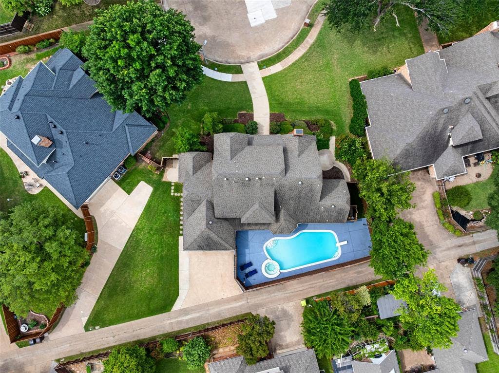 2705 Ithaca Court, Plano, TX 75025 Curved swimming pool with an integrated spa, surrounded by a paved patio