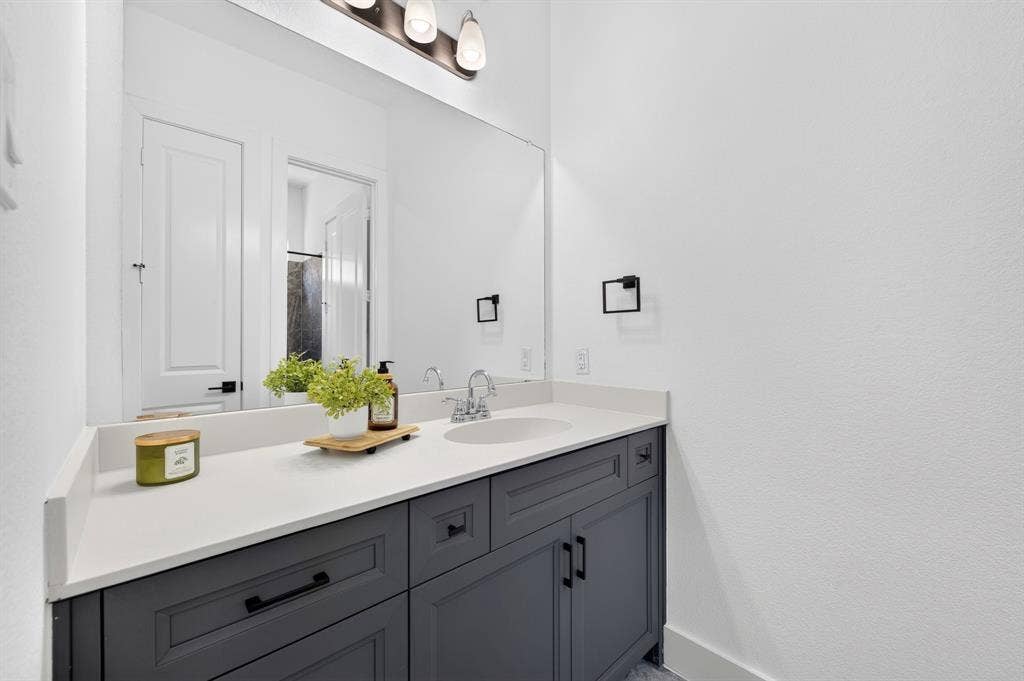 2809 Buckskin Lane, Northlake, TX 76247 Spacious vanity with a white countertop, undermount sink, and dark gray cabinetry
