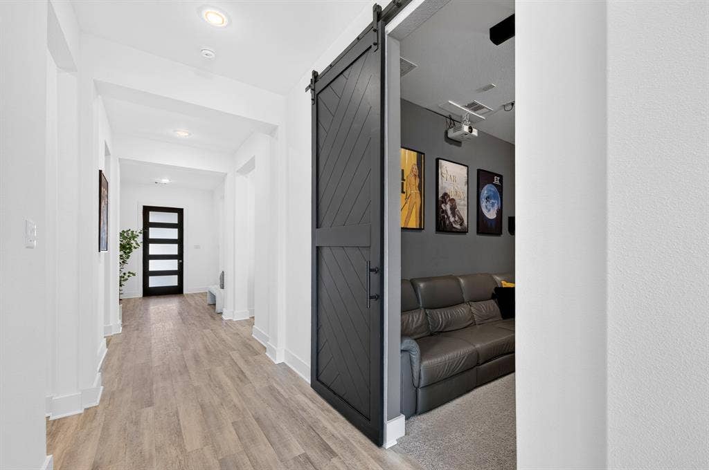 2809 Buckskin Lane, Northlake, TX 76247 Hallway with wood-finish flooring, recessed lighting, and a modern black barn door