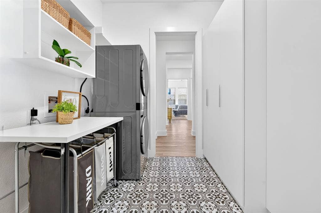 2809 Buckskin Lane, Northlake, TX 76247 Patterned floor tiling, built-in shelving, white flat-panel cabinetry, and a dedicated laundry area with stacked appliances