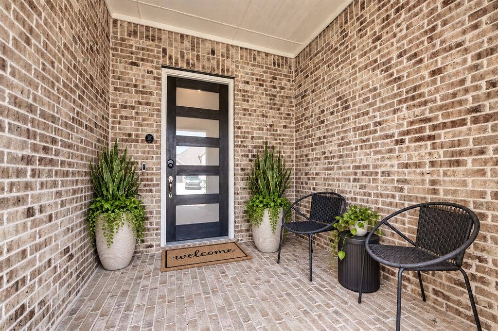 2809 Buckskin Lane, Northlake, TX 76247 Brick exterior with a covered porch and a contemporary front door featuring frosted glass panels