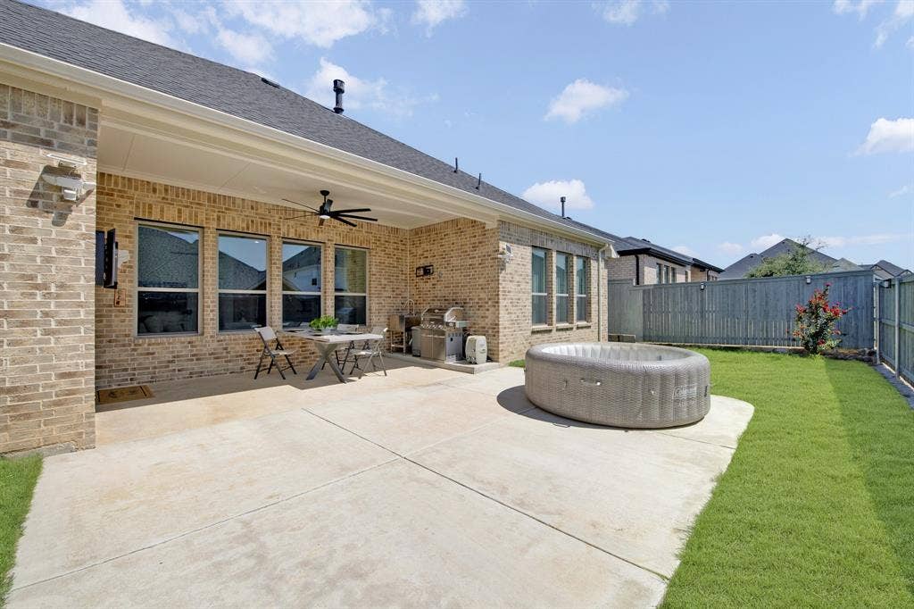 2809 Buckskin Lane, Northlake, TX 76247 Covered patio with a ceiling fan, brick exterior, multiple windows, concrete patio, and a grassy yard