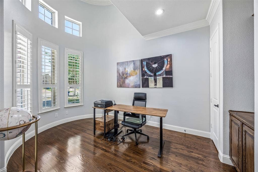 Office features built-ins, soaring ceilings and French doors