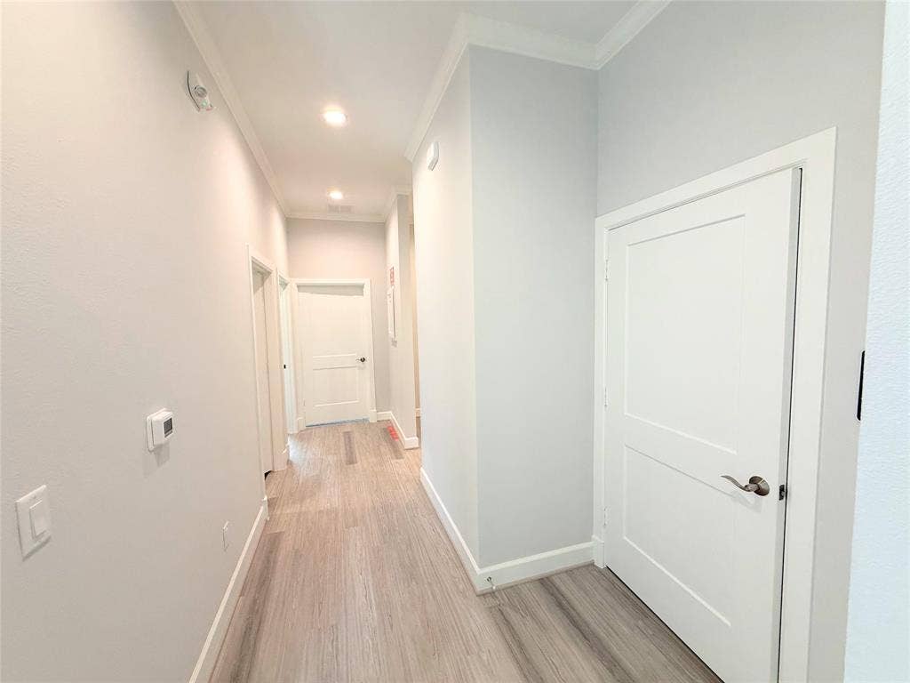 2120 Prairie Drive, #902, Prosper, TX 75078 Hallway featuring wood-finish flooring, recessed lighting, crown molding, and paneled interior doors with brushed nickel hardware