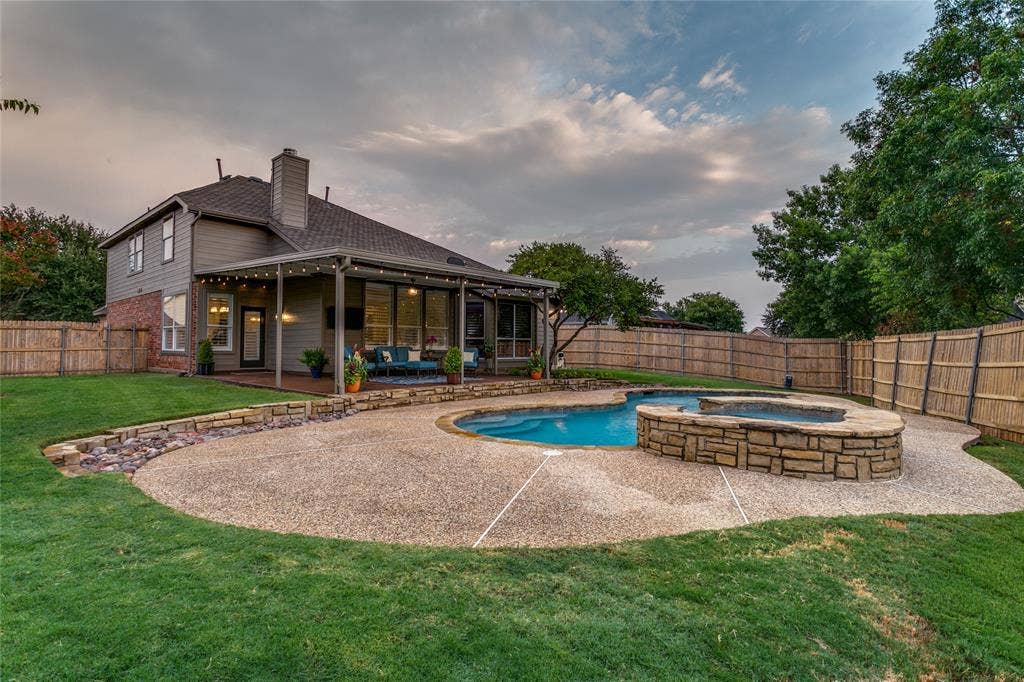 17 Adams Court, Mansfield, TX 76063 Expansive backyard featuring a curved concrete patio, in-ground swimming pool, and stone spa