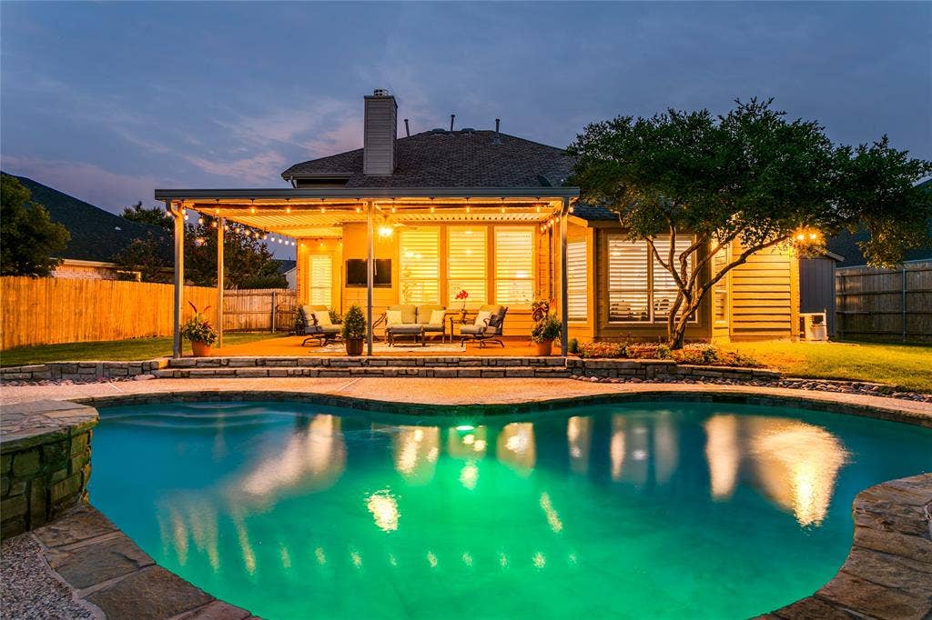 17 Adams Court, Mansfield, TX 76063 Resort-style backyard featuring a oversized custom-shaped swimming pool with stone coping, a spacious covered patio, and a manicured lawn