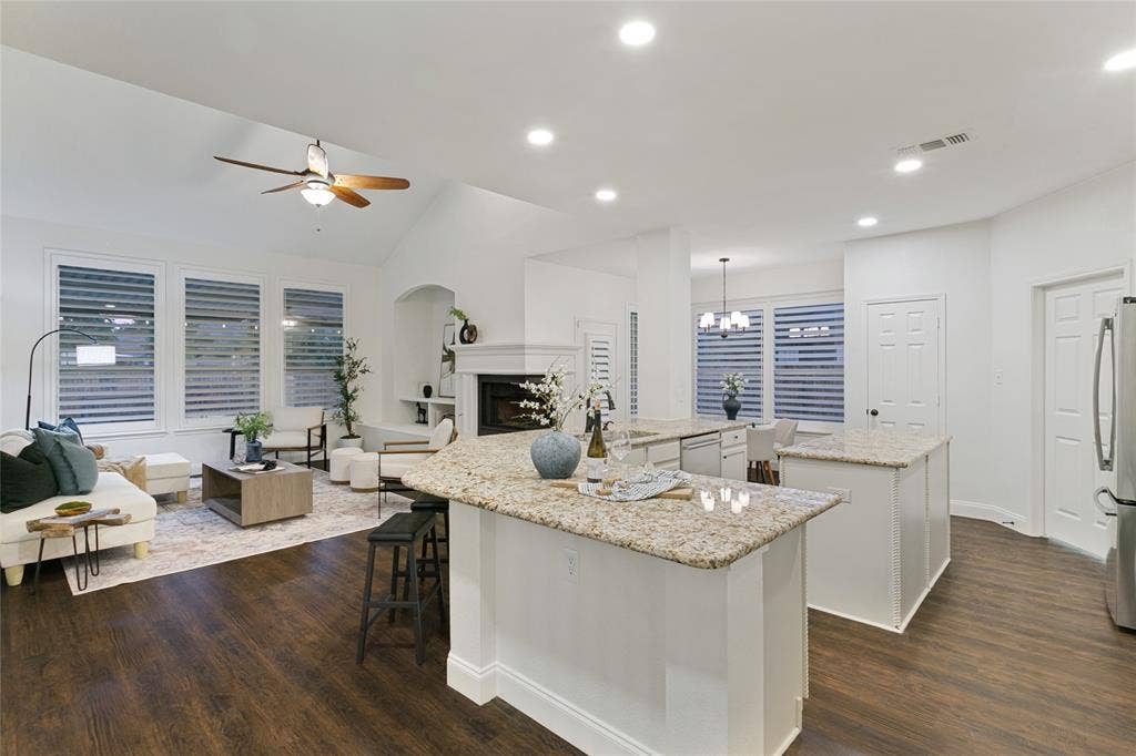 17 Adams Court, Mansfield, TX 76063 Vaulted ceiling with ceiling fan, recessed lighting, wood-finish flooring, white plantation shutters, and a fireplace with a white mantel