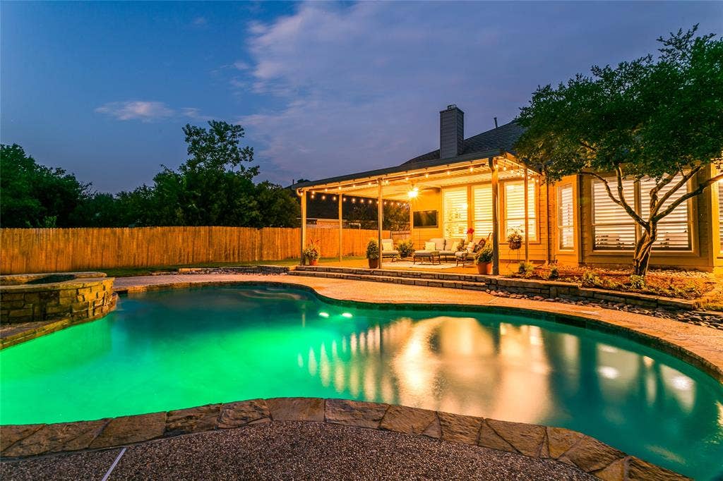 17 Adams Court, Mansfield, TX 76063 Curved swimming pool with integrated spa, stone coping, and illuminated water