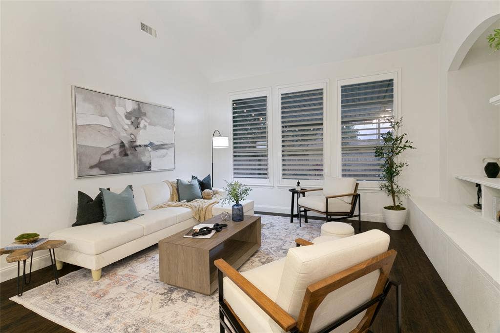 17 Adams Court, Mansfield, TX 76063 Vaulted ceiling, dark wood-finish flooring, white walls, multiple windows with shutters, and a built-in arched alcove