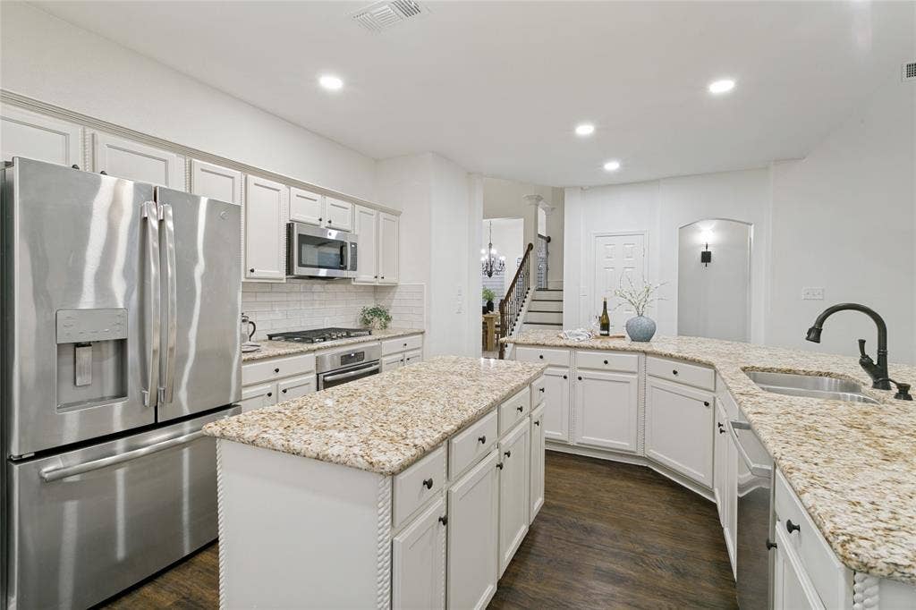 17 Adams Court, Mansfield, TX 76063 Kitchen featuring white cabinetry, stainless steel appliances, granite countertops, a center island, and wood-finish flooring