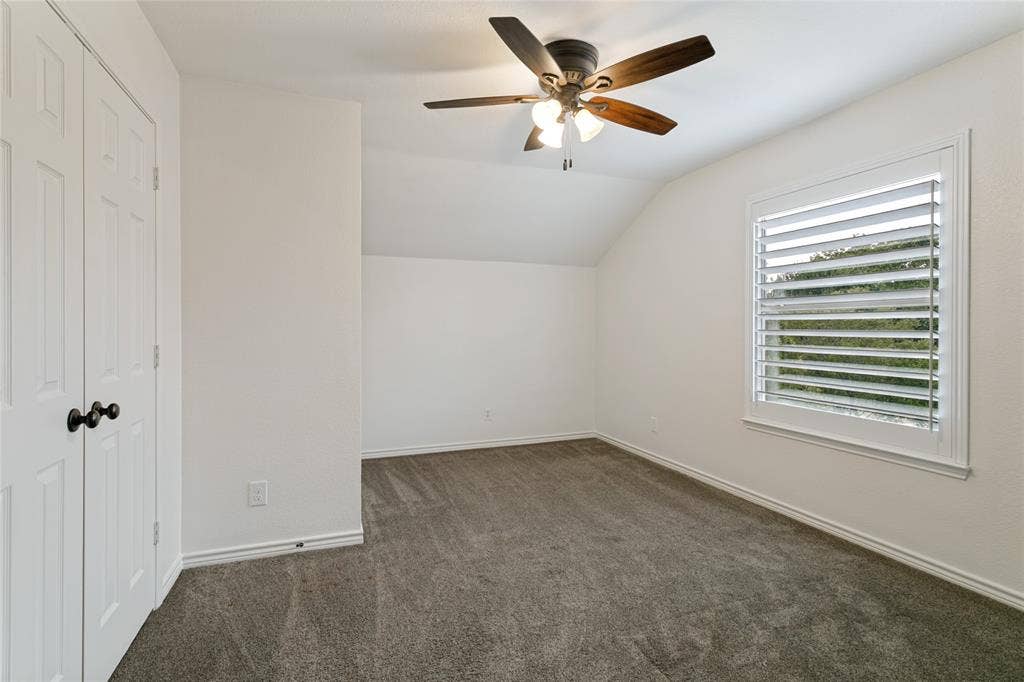 17 Adams Court, Mansfield, TX 76063 Carpeted room with a ceiling fan, window featuring plantation shutters, and a closet with bifold doors